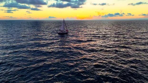 Aerial view of a sailboat on the ocean at sunset United States. Aerial view of a sailboat on the ocean at sunset United States.