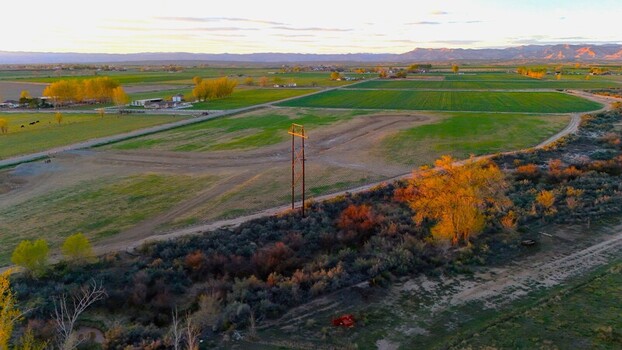 Aerial view of golden light bathing the fields and orchards near Fruita with the distant Book Cliffs painting the horizon in soft hues Fruita Colorado United States. Aerial view of golden light bathing the fields and orchards near Fruita with the distant Book Cliffs painting the horizon in soft hues Fruita Colorado United States.