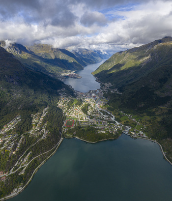 Aerial view of the town of Odda situated in a deep valley between towering mountains and the calm fjord waters Odda Vestland Norway. Aerial view of the town of Odda situated in a deep valley between towering mountains and the calm fjord waters Odda Vestland Norway.