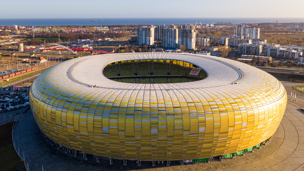 Gdansk Poland 27 March 2026 Aerial view of Polsat Plus Arena Gdansk a modern stadium with a yellow facade surrounded by urban buildings and infrastructure under a clear sky. Gdansk Poland 27 March 2026 Aerial view of Polsat Plus Arena Gdansk a modern stadium with a yellow facade surrounded by urban buildings and infrastructure under a clear sky.