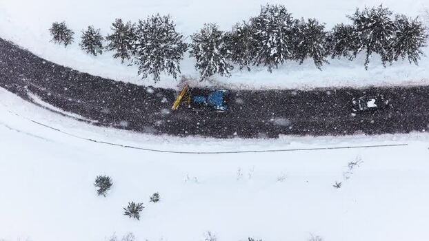 Aerial view of snowplow clearing road in Rivisondoli Italy.