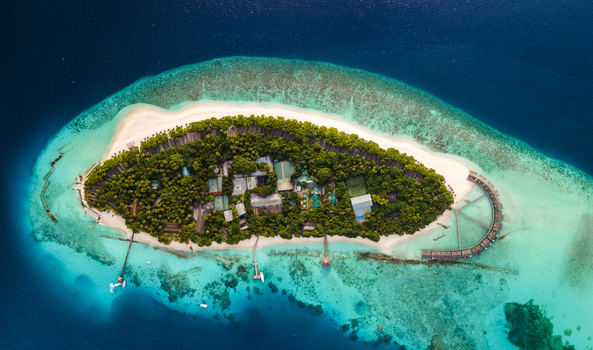 Panoramic aerial view of tropical island morning Baa Atoll Maldives.