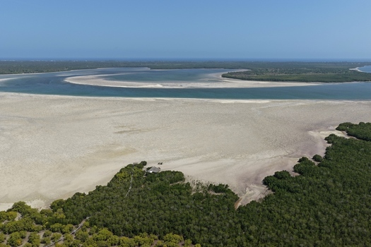 Aerial view of Mida Creek Nature Camp situated amidst vast tidal sandbanks dense mangrove forests and turquoise waters under a clear sky in Watamu Kilifi County Kenya.