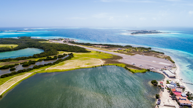 Aerial view of Los Roques archipelago featuring the airstrip turquoise Caribbean waters coastal vegetation and small buildings in Los Roques Dependencias Federale Venezuela. Aerial view of Los Roques archipelago featuring the airstrip turquoise Caribbean waters coastal vegetation and small buildings in Los Roques Dependencias Federale Venezuela.