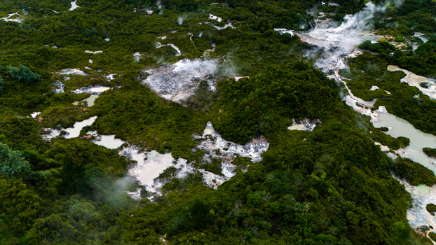 Aerial view of geothermal area with steam rising above mud pools and lush green vegetation Rotorua New Zealand. Aerial view of geothermal area with steam rising above mud pools and lush green vegetation Rotorua New Zealand.