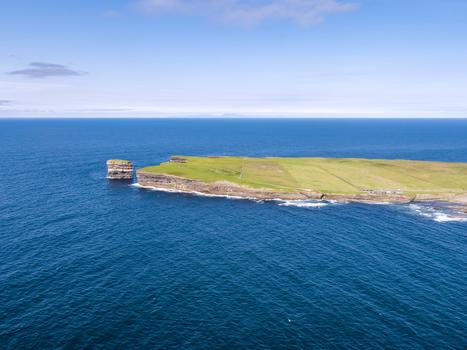 Aerial view of Dun Briste sea stack rising from the Atlantic Ocean near the grassy cliffs of Downpatrick Head in County Mayo Ireland. Aerial view of Dun Briste sea stack rising from the Atlantic Ocean near the grassy cliffs of Downpatrick Head in County Mayo Ireland.