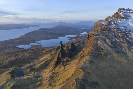 Aerial view of The Storr rock formation with its iconic pinnacles and snowy ridges overlooking Loch Leathan Isle of Skye Scotland United Kingdom. Aerial view of The Storr rock formation with its iconic pinnacles and snowy ridges overlooking Loch Leathan Isle of Skye Scotland United Kingdom.