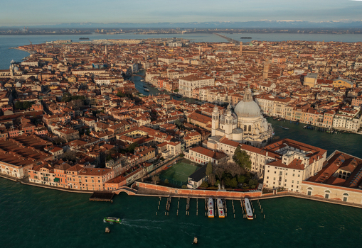 Aerial view of the historic city of Venice featuring the iconic Santa Maria della Salute basilica terracotta rooftops and winding canals in Venice Veneto Italy. Aerial view of the historic city of Venice featuring the iconic Santa Maria della Salute basilica terracotta rooftops and winding canals in Venice Veneto Italy.