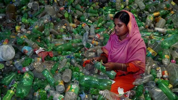 View of a woman sorting plastic bottles for recycling Bangladesh. View of a woman sorting plastic bottles for recycling Bangladesh.