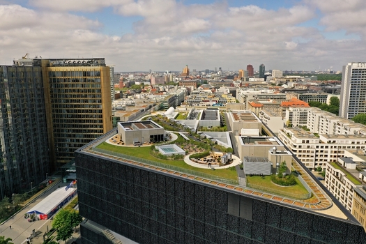 Aerial view of the Axel Springer Neubau featuring a modern green roof terrace and urban architecture under a cloudy sky in Berlin Berlin Germany. Aerial view of the Axel Springer Neubau featuring a modern green roof terrace and urban architecture under a cloudy sky in Berlin Berlin Germany.