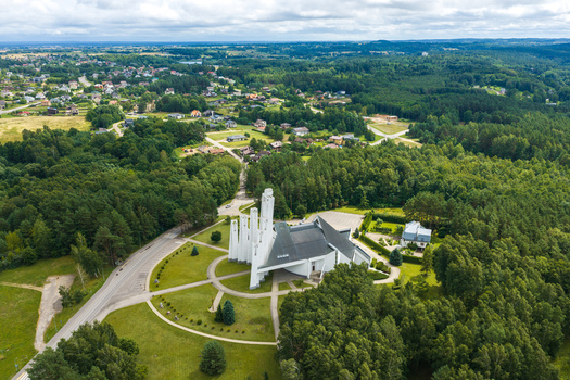 Aerial view of the modern Church of the Holy Virgin Mary surrounded by dense green forests and a small residential area in Elektrenai Vilnius County Lithuania. Aerial view of the modern Church of the Holy Virgin Mary surrounded by dense green forests and a small residential area in Elektrenai Vilnius County Lithuania.