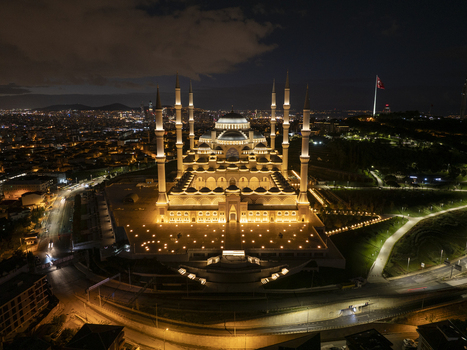 Aerial view of Grand Camlica Mosque illuminated at night with the sprawling city lights of Istanbul in the background in Uskudar Istanbul Turkiye. Aerial view of Grand Camlica Mosque illuminated at night with the sprawling city lights of Istanbul in the background in Uskudar Istanbul Turkiye.