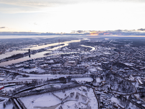 Aerial view of the snow covered city of Riga with the Daugava river and the Riga Radio and TV Tower visible under a soft winter sky in Riga Latvia.