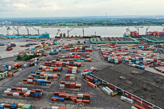 Aerial view of Chattogram Port with rows of colorful shipping containers cargo ships docked along the river and industrial infrastructure in Chittagong Chittagong Division Bangladesh.