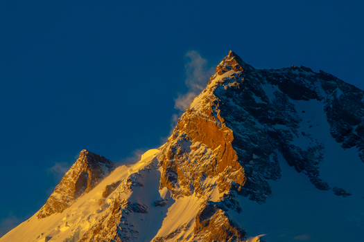 View of the snow capped peak of Nanga Parbat illuminated by golden hour light against a deep blue sky Fairy Meadow Gilgit Pakistan. View of the snow capped peak of Nanga Parbat illuminated by golden hour light against a deep blue sky Fairy Meadow Gilgit Pakistan.