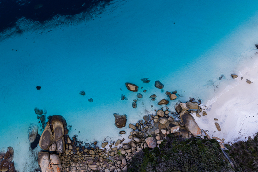 Aerial view of Frenchman Bay featuring turquoise water white sand beach and large granite boulders along the coastline in Albany Western Australia Australia. Aerial view of Frenchman Bay featuring turquoise water white sand beach and large granite boulders along the coastline in Albany Western Australia Australia.