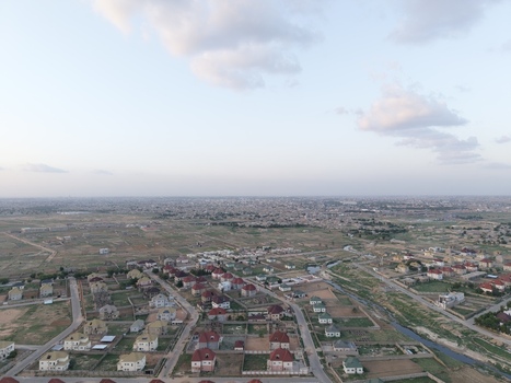 Aerial view of modern residential houses with red roofs and green gardens under a soft evening sky in Kano Kano Nigeria.
