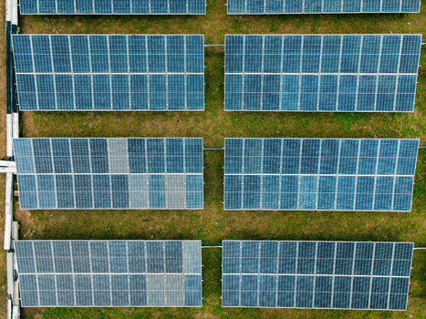 Aerial view of rows of solar panels installed in a grassy field in Ogun State Nigeria.
