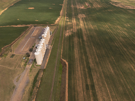 Aerial view of a large grain silo complex situated beside vast agricultural fields under a cloudy sky in Thabo Mofutsanyana District Municipality Free State South Africa. Aerial view of a large grain silo complex situated beside vast agricultural fields under a cloudy sky in Thabo Mofutsanyana District Municipality Free State South Africa.