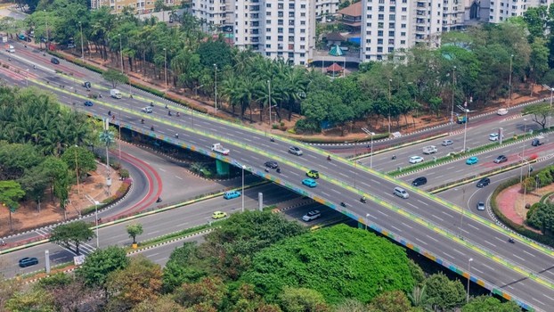 Aerial view of a busy highway interchange with multi level roads flowing traffic and surrounding lush greenery in the urban landscape of Jakarta Indonesia. Aerial view of a busy highway interchange with multi level roads flowing traffic and surrounding lush greenery in the urban landscape of Jakarta Indonesia.
