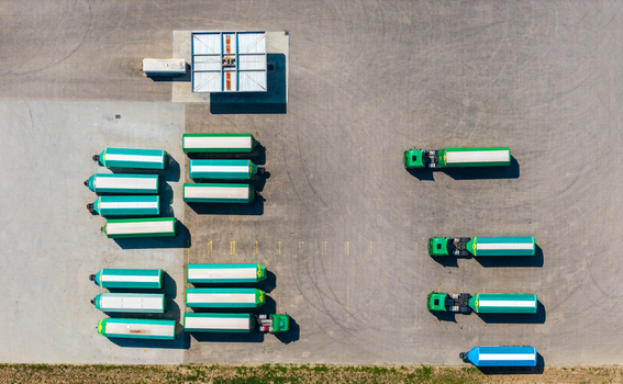 Aerial view of Hombourg Logistic park with green and white trucks and trailers parked in an orderly fashion on asphalt in Hombourg Grand Est France.