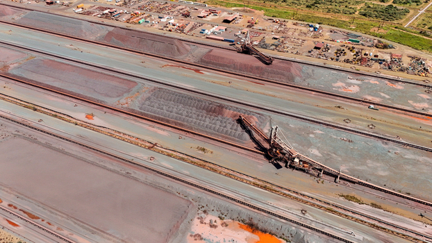 Aerial view of vast industrial landscape with rich russet earth mounds and powerful ore handling machinery under a bright sky Rustenburg North West South Africa. Aerial view of vast industrial landscape with rich russet earth mounds and powerful ore handling machinery under a bright sky Rustenburg North West South Africa.