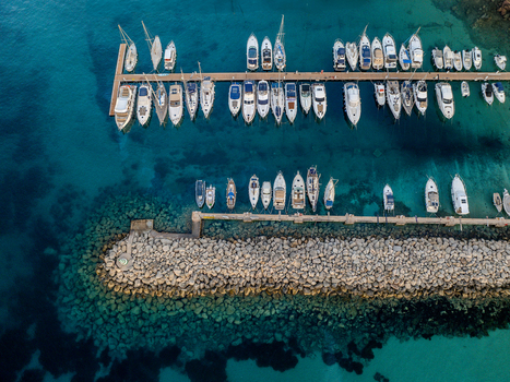 Aerial view of boats resting in the marina against the azure waters of the harbour contrasting with the rocky breakwater Mgarr Harbour Gozo Malta. Aerial view of boats resting in the marina against the azure waters of the harbour contrasting with the rocky breakwater Mgarr Harbour Gozo Malta.
