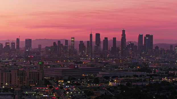 Aerial view of the Los Angeles skyline at sunset with vibrant pink clouds over the city buildings and urban landscape in Los Angeles California United States.