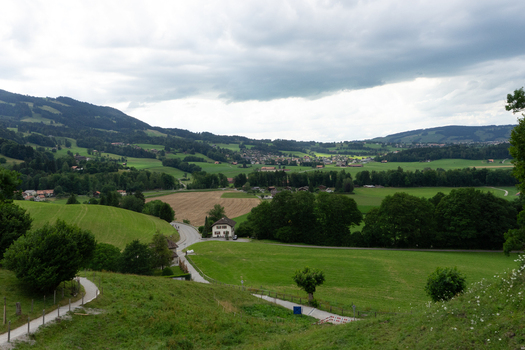 14 May 2026 View of a lush green valley with rolling hills scattered farmhouses and a small village under a dramatic cloudy sky. 14 May 2026 View of a lush green valley with rolling hills scattered farmhouses and a small village under a dramatic cloudy sky.