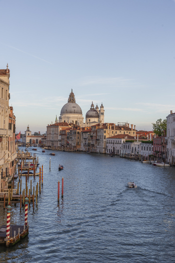 View of the Santa Maria della Salute basilica overlooking the Grand Canal with historic buildings and boats in the golden hour light in Venice Veneto Italy. View of the Santa Maria della Salute basilica overlooking the Grand Canal with historic buildings and boats in the golden hour light in Venice Veneto Italy.