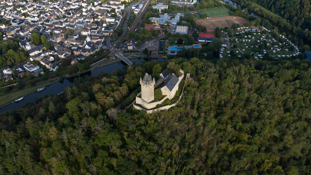 Aerial view of Nassau Castle perched on a forested hill overlooking the Lahn river and the town of Nassau Rheinland Pfalz Germany.