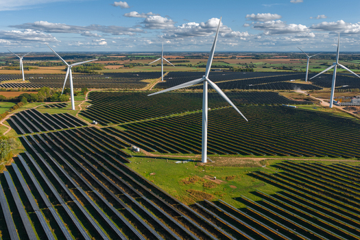Aerial view of Chelveston Renewable Energy BESS featuring rows of solar panels and wind turbines in a rural landscape Chelveston England United Kingdom. Aerial view of Chelveston Renewable Energy BESS featuring rows of solar panels and wind turbines in a rural landscape Chelveston England United Kingdom.