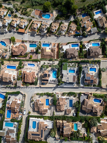 Aerial view of residential villas with swimming pools and terracotta roofs in Moraira Valencian Community Spain.
