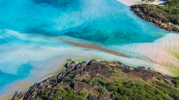 Aerial view of Chance Bay featuring turquoise waters white sand beaches and rocky coastline with lush vegetation in Whitsundays Queensland Australia. Aerial view of Chance Bay featuring turquoise waters white sand beaches and rocky coastline with lush vegetation in Whitsundays Queensland Australia.