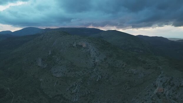 Aerial view of rugged mountains under a cloudy sky in Spain.