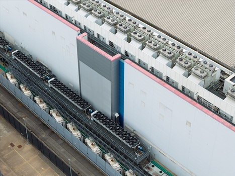 Aerial view of a data center featuring rows of industrial cooling units and HVAC systems on the roof of a large building United Kingdom.