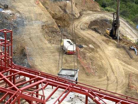 View of a construction site featuring red steel framework a drilling rig and a white truck on a dirt hillside in Sariyer Istanbul Turkiye.