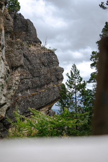 View of the Indian Head rock formation surrounded by evergreen trees under a cloudy sky in Bariloche Department Rio Negro Province Argentina. View of the Indian Head rock formation surrounded by evergreen trees under a cloudy sky in Bariloche Department Rio Negro Province Argentina.