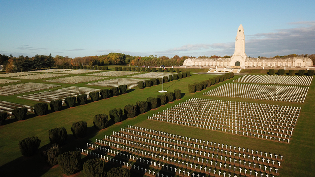 Aerial view of the Douaumont Ossuary a memorial for World War I soldiers surrounded by rows of white crosses in a military cemetery in Douaumont Vaux Grand Est France.