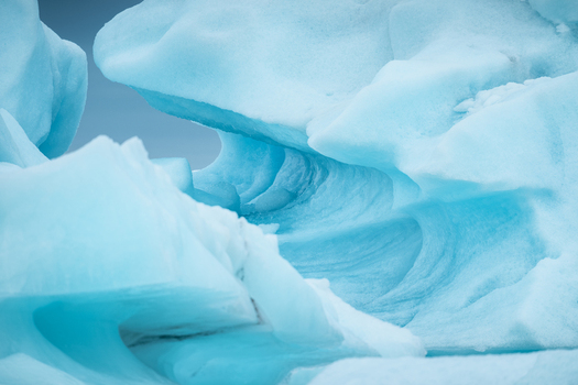 View of Vatnajokull glacier ice formations with intricate blue textures and smooth curves Iceland.