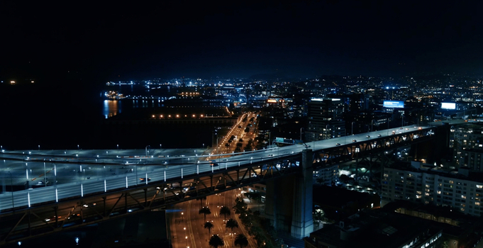 Aerial view of San Francisco Oakland Bay Bridge illuminated at night with city lights and traffic flowing across the structure in San Francisco California United States. Aerial view of San Francisco Oakland Bay Bridge illuminated at night with city lights and traffic flowing across the structure in San Francisco California United States.