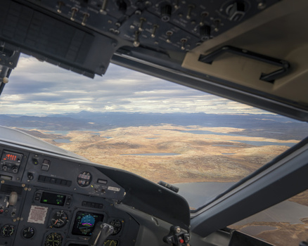 Aerial view of the expansive ruddy terrain stretching towards the horizon framed by the cockpit s intricate controls Narsarsuaq Greenland. Aerial view of the expansive ruddy terrain stretching towards the horizon framed by the cockpit s intricate controls Narsarsuaq Greenland.