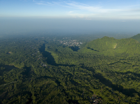 Aerial view of the lush green forest surrounding Bunker Kaliadem Merapi with deep valleys and hills under a clear sky in Kecamatan Pakem Daerah Istimewa Yogya Indonesia. Aerial view of the lush green forest surrounding Bunker Kaliadem Merapi with deep valleys and hills under a clear sky in Kecamatan Pakem Daerah Istimewa Yogya Indonesia.