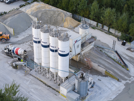 Krakow Poland 16 September 2026 Aerial view of the CEMEX concrete batching plant featuring tall white silos a cement mixer truck and piles of aggregate. Krakow Poland 16 September 2026 Aerial view of the CEMEX concrete batching plant featuring tall white silos a cement mixer truck and piles of aggregate.
