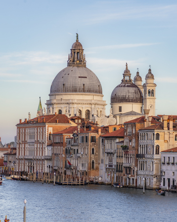 View of the Santa Maria della Salute basilica with its iconic domes rising above the historic buildings along the Grand Canal in Venice Veneto Italy. View of the Santa Maria della Salute basilica with its iconic domes rising above the historic buildings along the Grand Canal in Venice Veneto Italy.