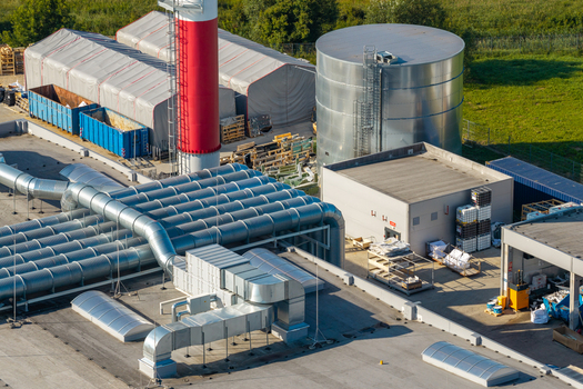 Aerial view of an advanced motorboat production facility featuring large ventilation ducts a cylindrical storage tank and industrial storage tents in Poland.