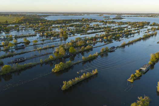 Aerial view of Scheendijk featuring narrow strips of land with small houses and lush trees surrounded by the calm waters of the Loosdrecht lakes in Breukelen Utrecht Netherlands. Aerial view of Scheendijk featuring narrow strips of land with small houses and lush trees surrounded by the calm waters of the Loosdrecht lakes in Breukelen Utrecht Netherlands.
