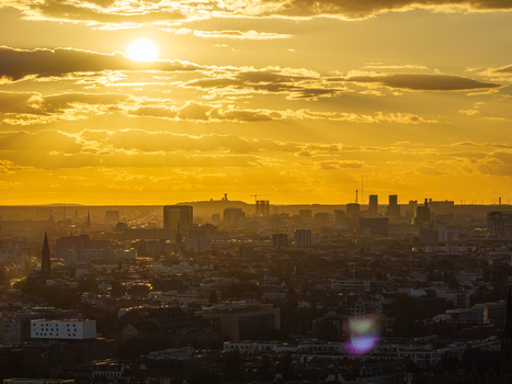 Aerial view of the Berlin skyline featuring the Teufelsberg hill under a warm golden hour sunset with urban rooftops and city architecture in Berlin Berlin Germany. Aerial view of the Berlin skyline featuring the Teufelsberg hill under a warm golden hour sunset with urban rooftops and city architecture in Berlin Berlin Germany.