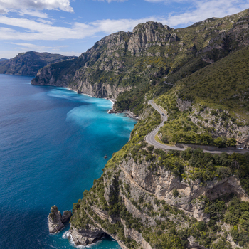 Aerial view of the Amalfi Coast Drive winds along rugged cliffs where turquoise waters meet verdant hillsides in a stunning display of nature s artistry Amalfi Campania Italy. Aerial view of the Amalfi Coast Drive winds along rugged cliffs where turquoise waters meet verdant hillsides in a stunning display of nature s artistry Amalfi Campania Italy.