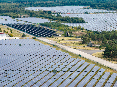 Aerial view of the former military airfield in Preschen now a solar farm with historic hangars and runway remnants visible among solar panels in Neisse Malxetal Brandenburg Germany. Aerial view of the former military airfield in Preschen now a solar farm with historic hangars and runway remnants visible among solar panels in Neisse Malxetal Brandenburg Germany.